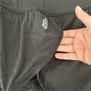 "FP Movement Black Ribbed Waistband Run Shorts with Open Crossover Sides.